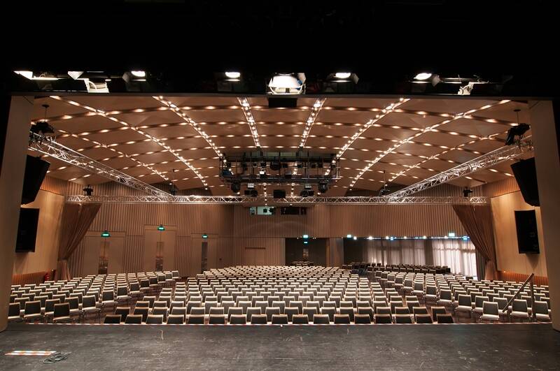 Blick von der Bühne in den beleuchteten und bestuhlten Saal