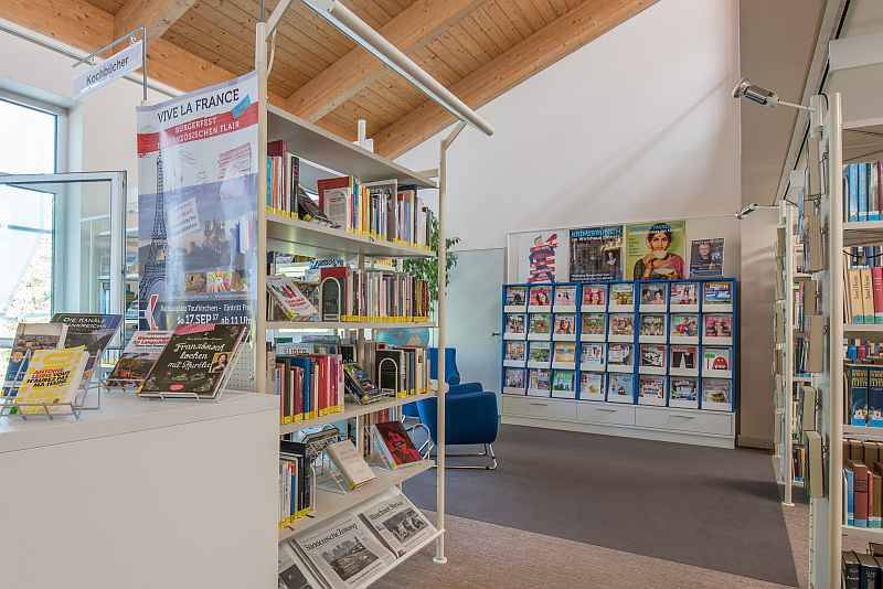 Gefüllte Bücherregale stehen in einem Raum mit Holzdecke