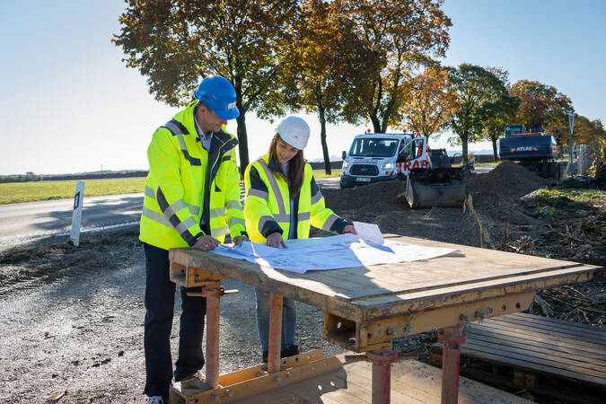 Baustelle mit Plantisch und zwei Mitarbeitenden