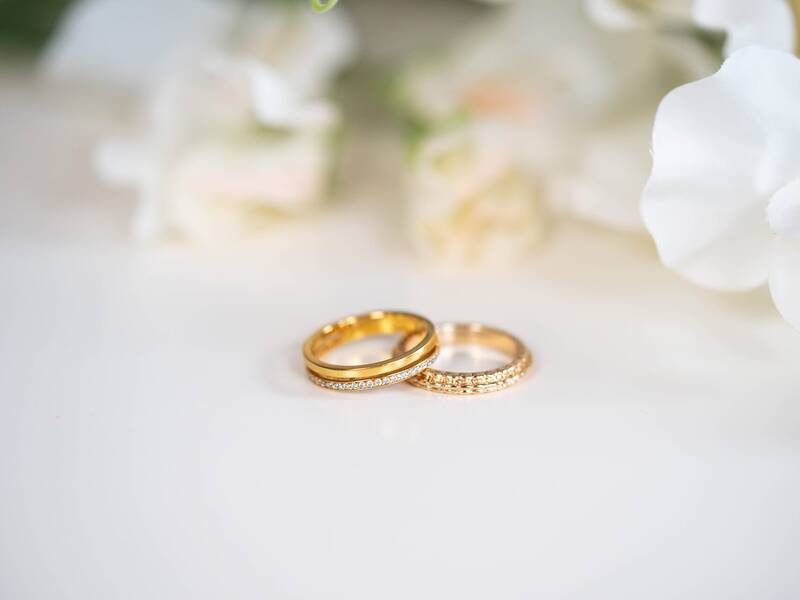 Zwei goldene Ringe liegen auf einem grauen Tisch