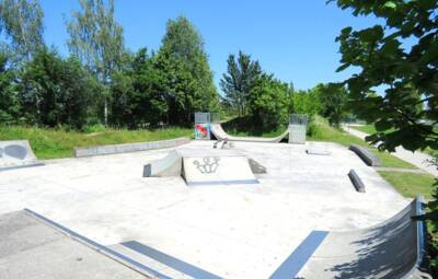 Skater  Hindernispark umgeben von grünen Bäumen und blauem Himmel